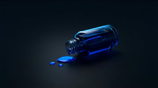 Glass dropper bottle with blue liquid on dark surface — methylene blue supplement